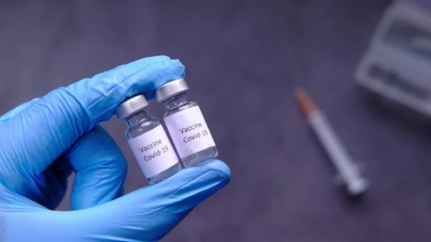 Arzt Hand in Schutzhandschuhe mit Coronavirus-Impfstoff, Ansicht von oben — Stockvideo