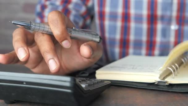 Primer plano de la mano del hombre usando la calculadora — Vídeos de Stock