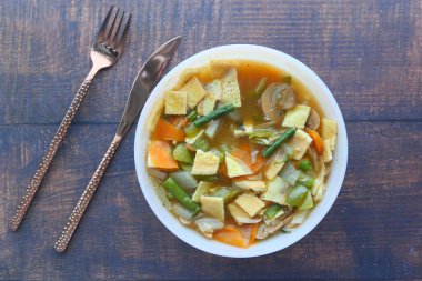  Siyah arka planda tavuk sebze çorbası.