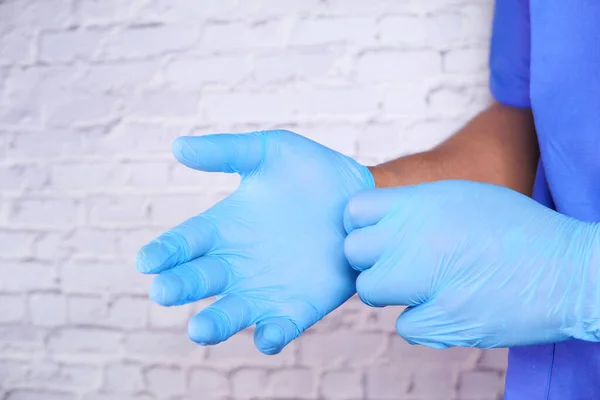 man doctor wears medical gloves, close up