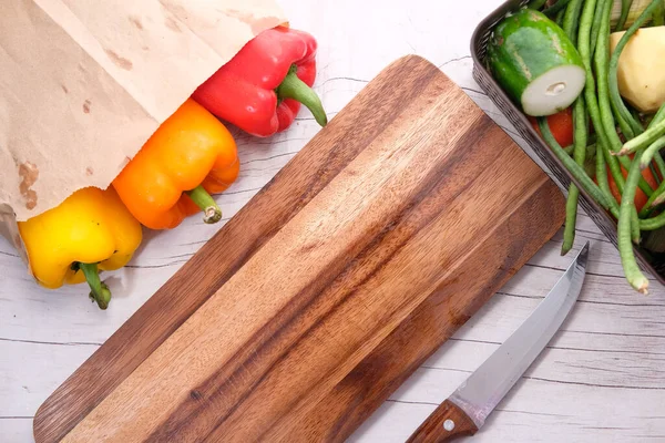 Amarelo laranja e capsicum vermelho com tábua de corte na mesa — Fotografia de Stock