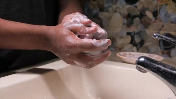 Młody człowiek myje ręce ciepłą wodą z mydłem — Wideo stockowe
