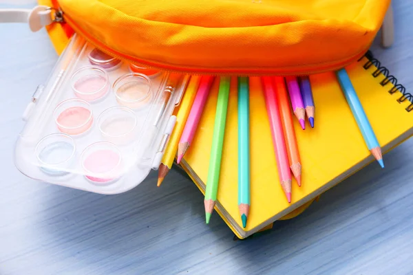 Concepto de vuelta a la escuela con mochila amarilla y proveedores escolares en la mesa — Foto de Stock