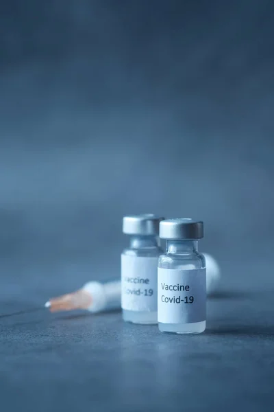 Закрытие коронавирусной вакцины и шприца на черном фоне — стоковое фото