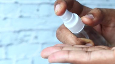 Delikanlının elini dezenfektan spreyiyle kapat..