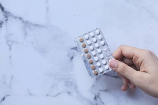 Vrouwen hand houden anticonceptiepillen bovenaanzicht — Stockfoto