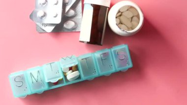 Steteskopun düz bileşimi ve pembe arka planda haplar 