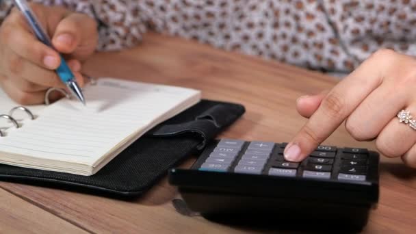 Mano de las mujeres usando calculadora en escritorio de oficina — Vídeos de Stock