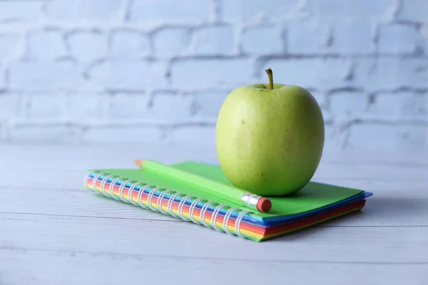 Concept noir à l'école avec pomme sur bloc-notes sur la table. — Photo