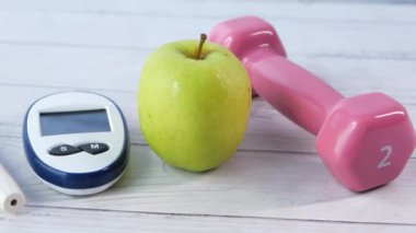 Masadaki şeker hastalığı ölçüm araçlarını, elmayı ve dambılı kapat 