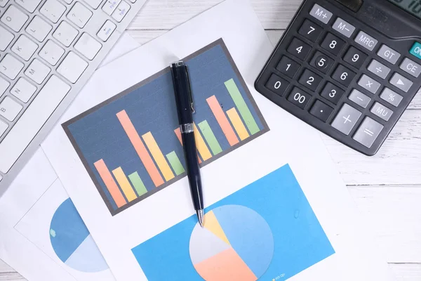 financial graph, calculator and notepad on table