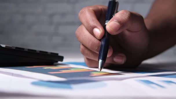 Mão homem com caneta analisando gráfico de barras no papel — Vídeo de Stock