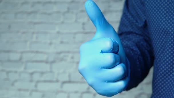 Närbild av personer hand i medicinska handskar visar en tumme-up. — Stockvideo