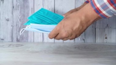  Adam elinde cerrahi maske tutuyor, yakın plan. 