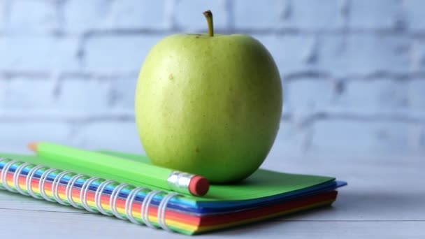 Conceito preto para a escola com maçã no bloco de notas na mesa. — Vídeo de Stock