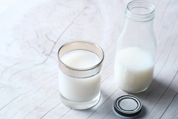 Primer plano de vaso de leche y frasco en la mesa — Foto de Stock