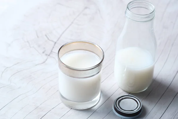 Närbild av glas mjölk och burk på bordet — Stockfoto