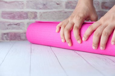 Kadın oturma odasında egzersiz paspası sallıyor.