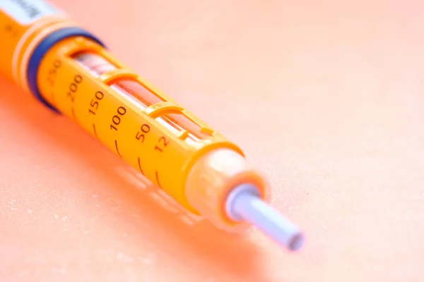 Nahaufnahme orangefarbener Farbe Insulin-Stifte auf Farbhintergrund — Stockfoto