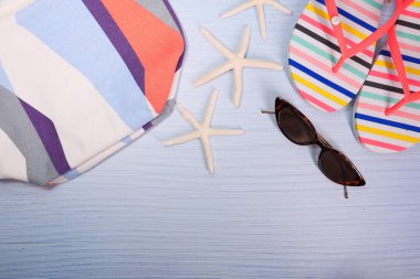 Masadaki plaj aksesuarlarının düz kompozisyonu.