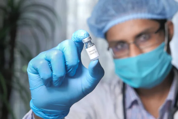 Γιατρός χέρι σε γάντια που κρατούν το εμβόλιο coronavirus, κοντινό πλάνο — Φωτογραφία Αρχείου