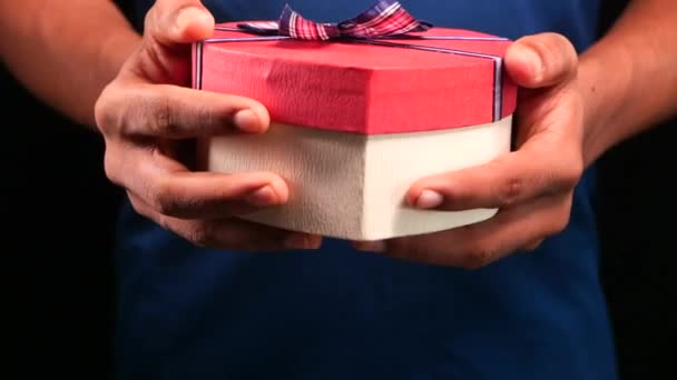 Primer plano de la mano sosteniendo la forma del corazón caja de regalo — Vídeos de Stock