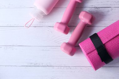  Pembe halterler, spor paspası ve beyaz arka planda su şişesi. 