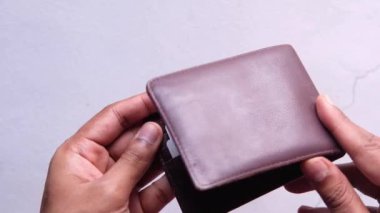 Adamın eli cüzdanından kredi kartını çıkarıyor. 