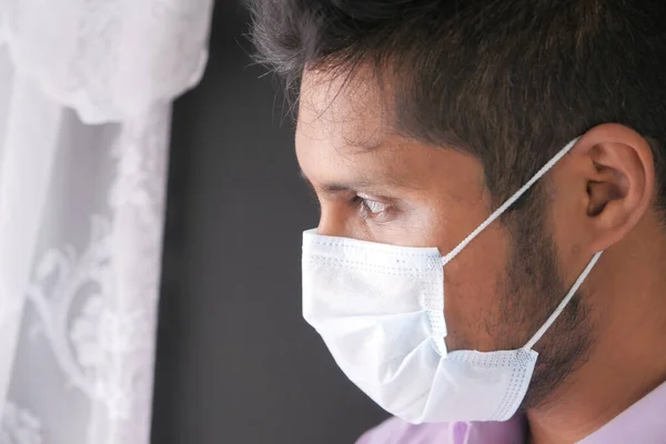 Ένας νεαρός Ασιάτης με προστατευτική μάσκα στο πρόσωπο αισθάνεται λυπημένος — Φωτογραφία Αρχείου