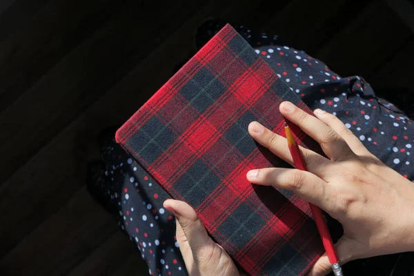 Ansicht von oben: Frauen halten ein Tagebuch in der Hand — Stockfoto