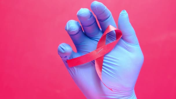 Mano sosteniendo la cinta roja del VIH de arriba hacia abajo — Vídeos de Stock