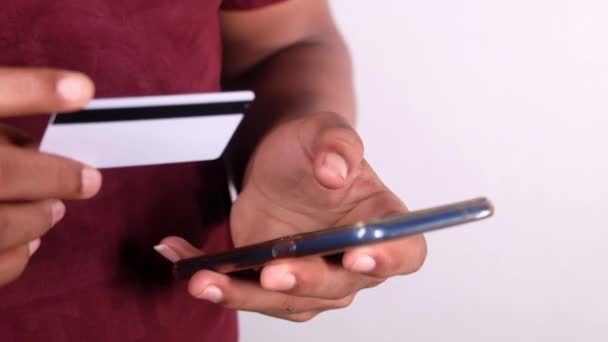 Рука людини тримає кредитну картку і використовує смартфон покупки в Інтернеті — стокове відео