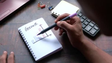 Not defterine el çizelgesi çizen kalem analizi yapan bir adam eli. 