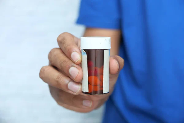 Close up of person hand holding pill container