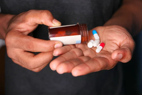 Primer plano de la mano del hombre tomando la medicina — Foto de Stock