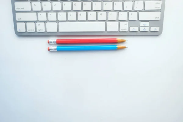 Vista superior del teclado y lápices de color sobre fondo blanco — Foto de Stock