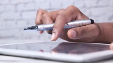 Ofis masasında dijital tablet üzerinde çalışan adamlar.,