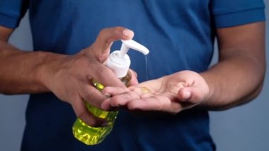 Virüsü önlemek için dezenfektan jel kullanarak genç adamın elini kapat. 