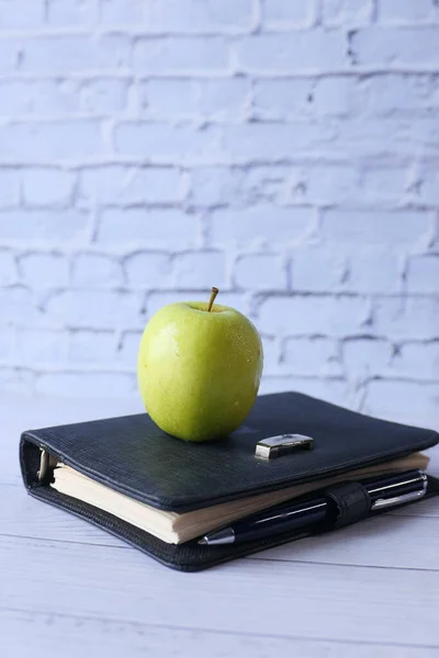 Concept noir à l'école avec pomme sur bloc-notes sur la table. — Photo