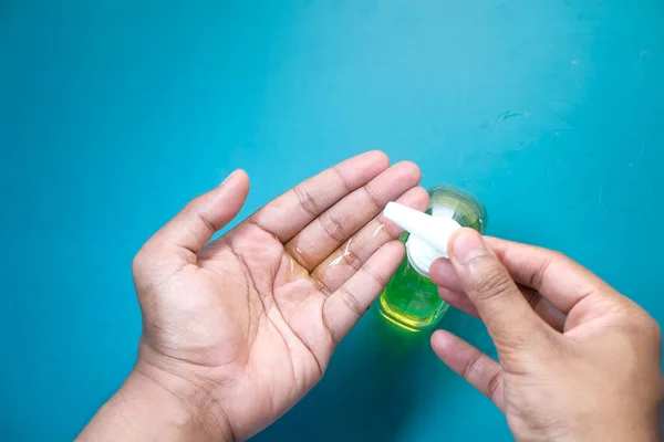 Primer plano de la mano del hombre joven usando gel desinfectante para prevenir el virus — Foto de Stock