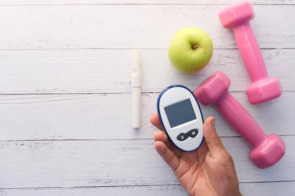 关闭糖尿病测量工具，苹果和哑铃放在桌上 — 图库照片