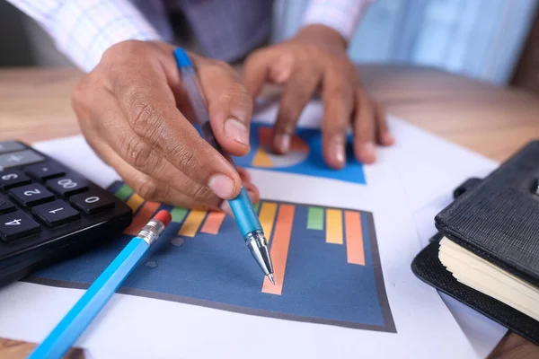 Mano de hombre con pluma analizando gráfico de barras en papel — Foto de Stock