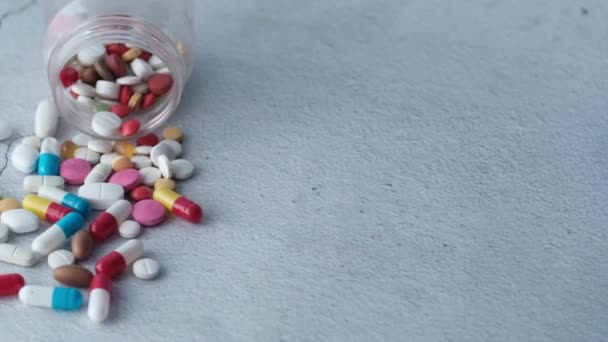 Nahaufnahme von bunten Pillen, die auf weißem Hintergrund verschüttet werden — Stockvideo