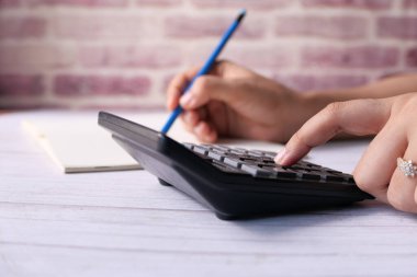 Kadınlar ofis masasında hesap makinesi kullanıyorlar. 
