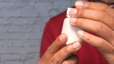 El ele tutuşan kişinin ilaç kutusunu kapat. 