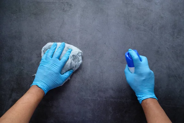 Hand in blauwe rubberen handschoenen reinigingstafel met doek — Stockfoto