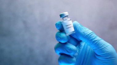 Doktor elinde koronavirüs aşısı olan eldivenleri teslim et.
