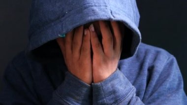 Kapüşonlu üzgün adam elleri siyah kaplı..