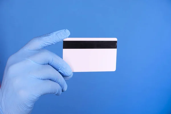 close up of person hand in protective gloves holding credit card