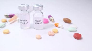Beyaz zemin üzerinde Coronavirus aşısı ve şırınga kapatın